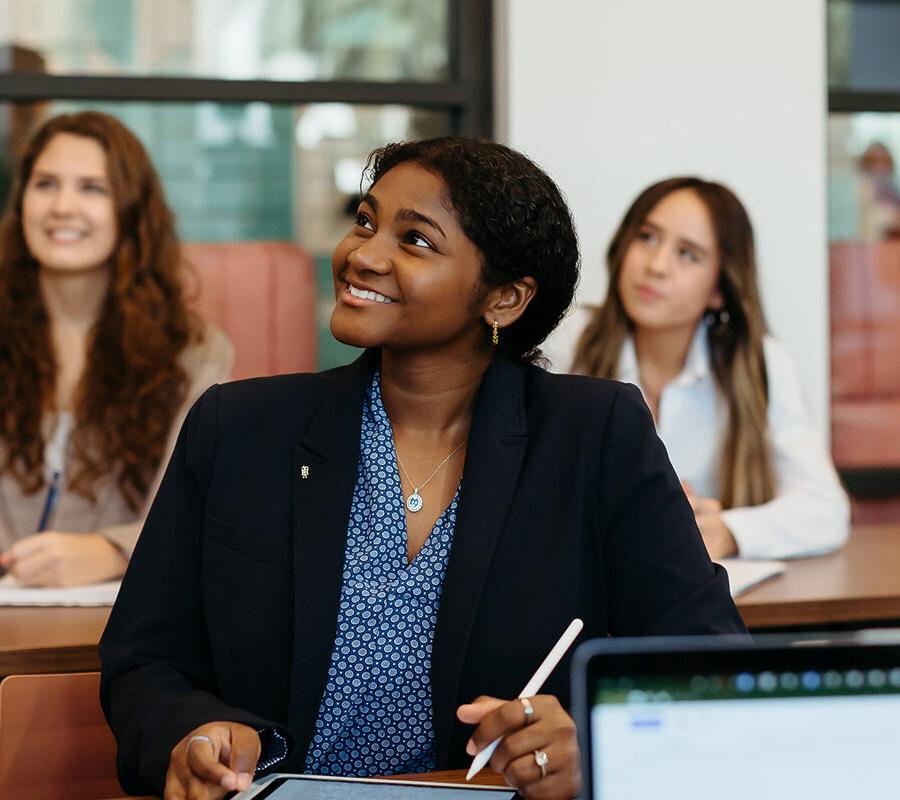 female students smiling and taking notes at 十大赌博网站